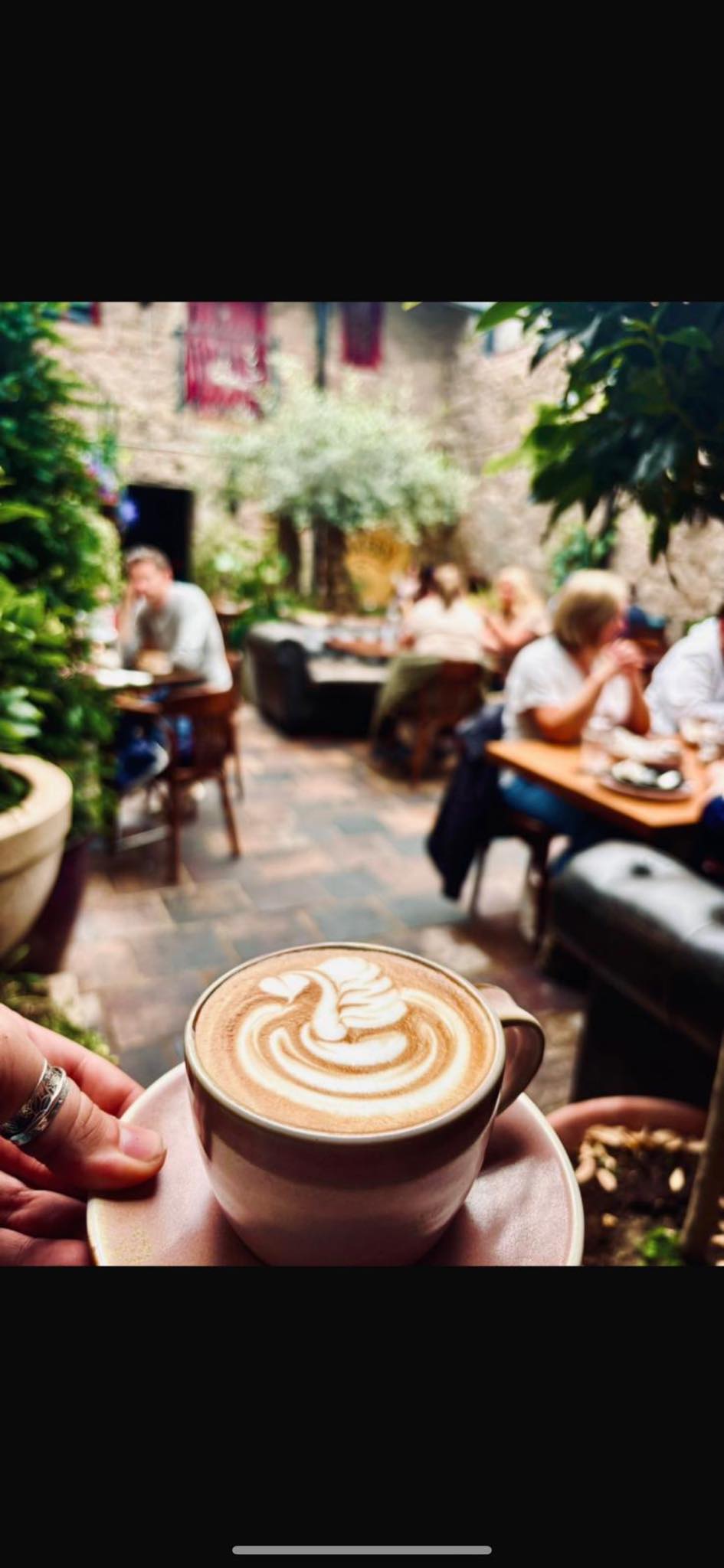 A latte held in the Cozy Corner courtyard